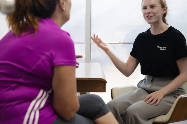 Chiropractor explaining shoulder pain to patient in Mona Vale chiropractic clinic